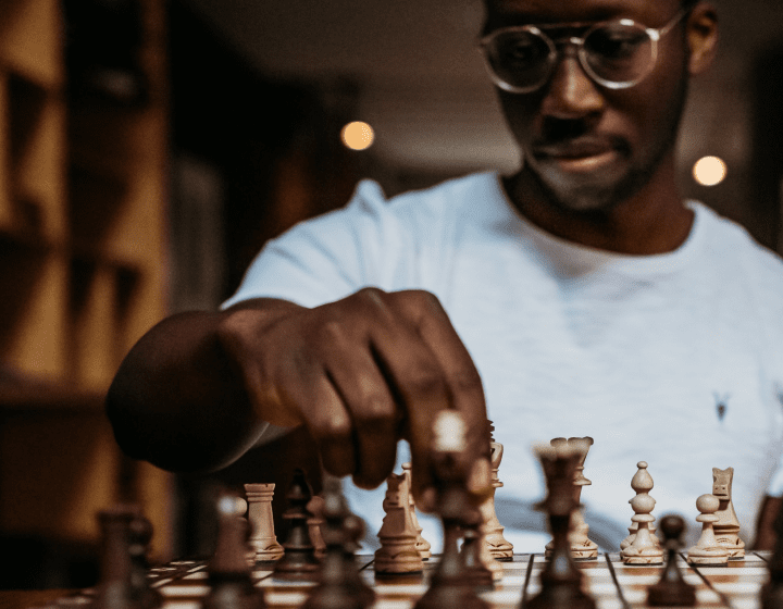 Homem negro de óculos jogando xadrez
